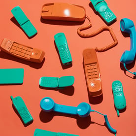 A selection of green, blue and orange telephones.
