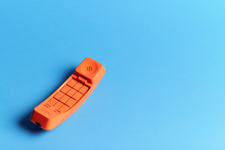 A disconnected orange telephone receiver.