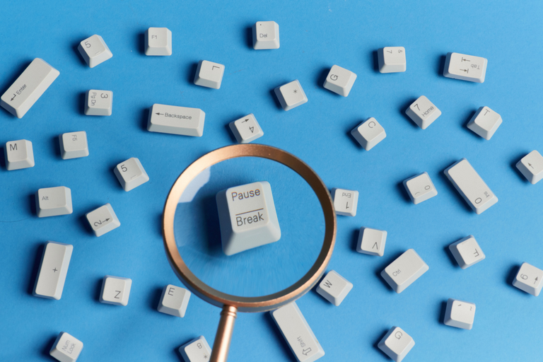 Scattered loose keyboard key-caps. Through a magnifying glass, the 